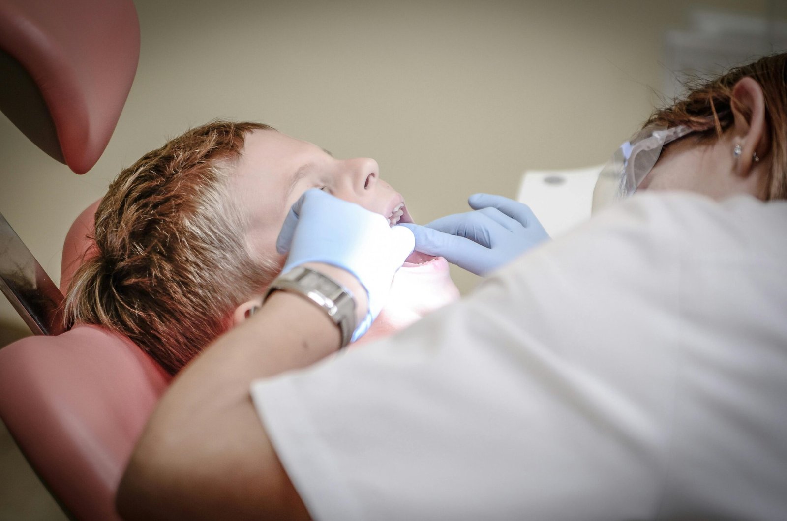 a child with a dentist's hand on his mouth